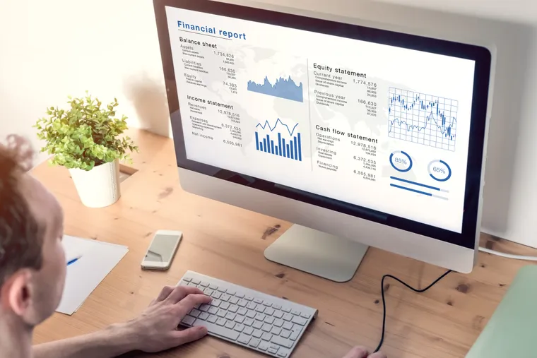 Accountant analyzing financial reports on a desktop computer