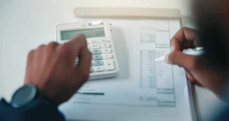 Tax professional calculating figures beside financial documents