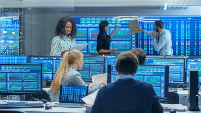 Investment team monitoring market data in a trading room