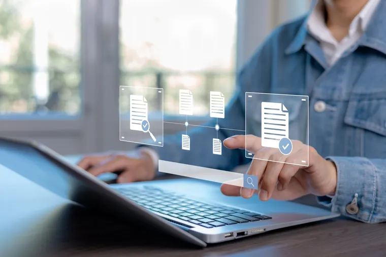 Professional validating digital business documents on a laptop