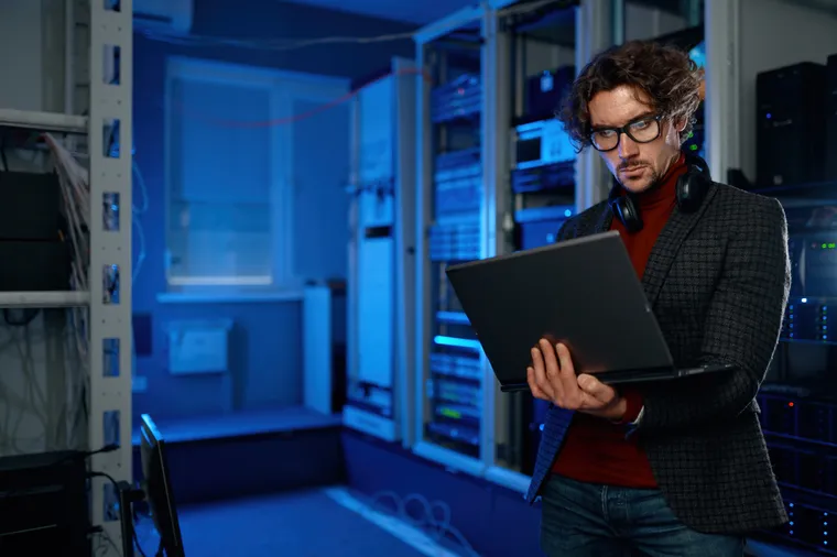 Network engineer inspecting equipment in a server room