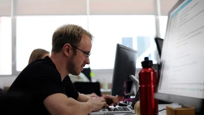 An IT support specialist helping a client at their desk
