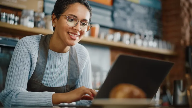 Small business owner managing her cafe from a laptop
